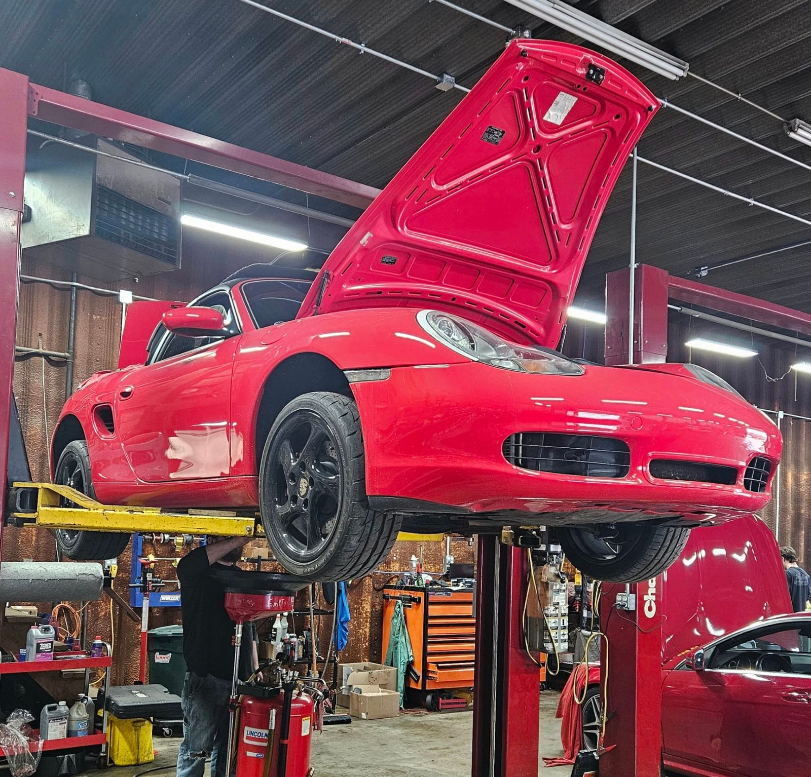 Red Porsche Boxster up on the lift