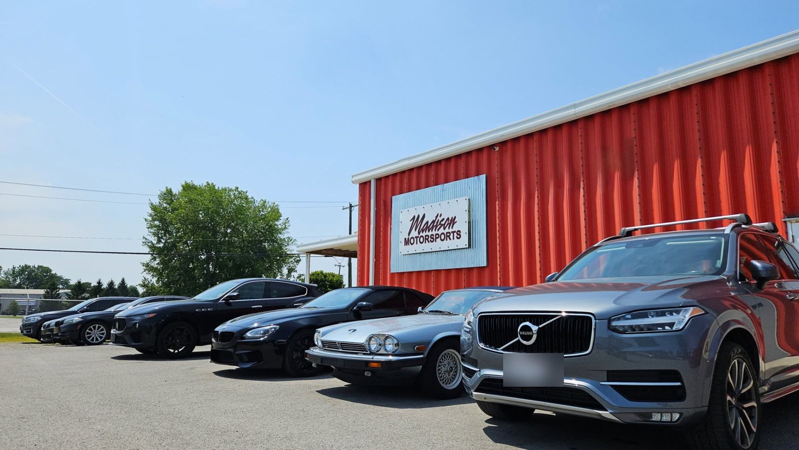 Volvo XC90, Jaguar and BMW parked along the shop